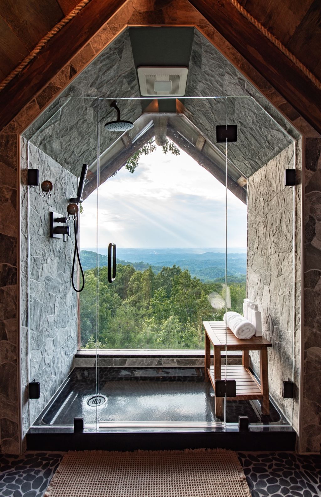 Stone walk-in shower with a mountain view window