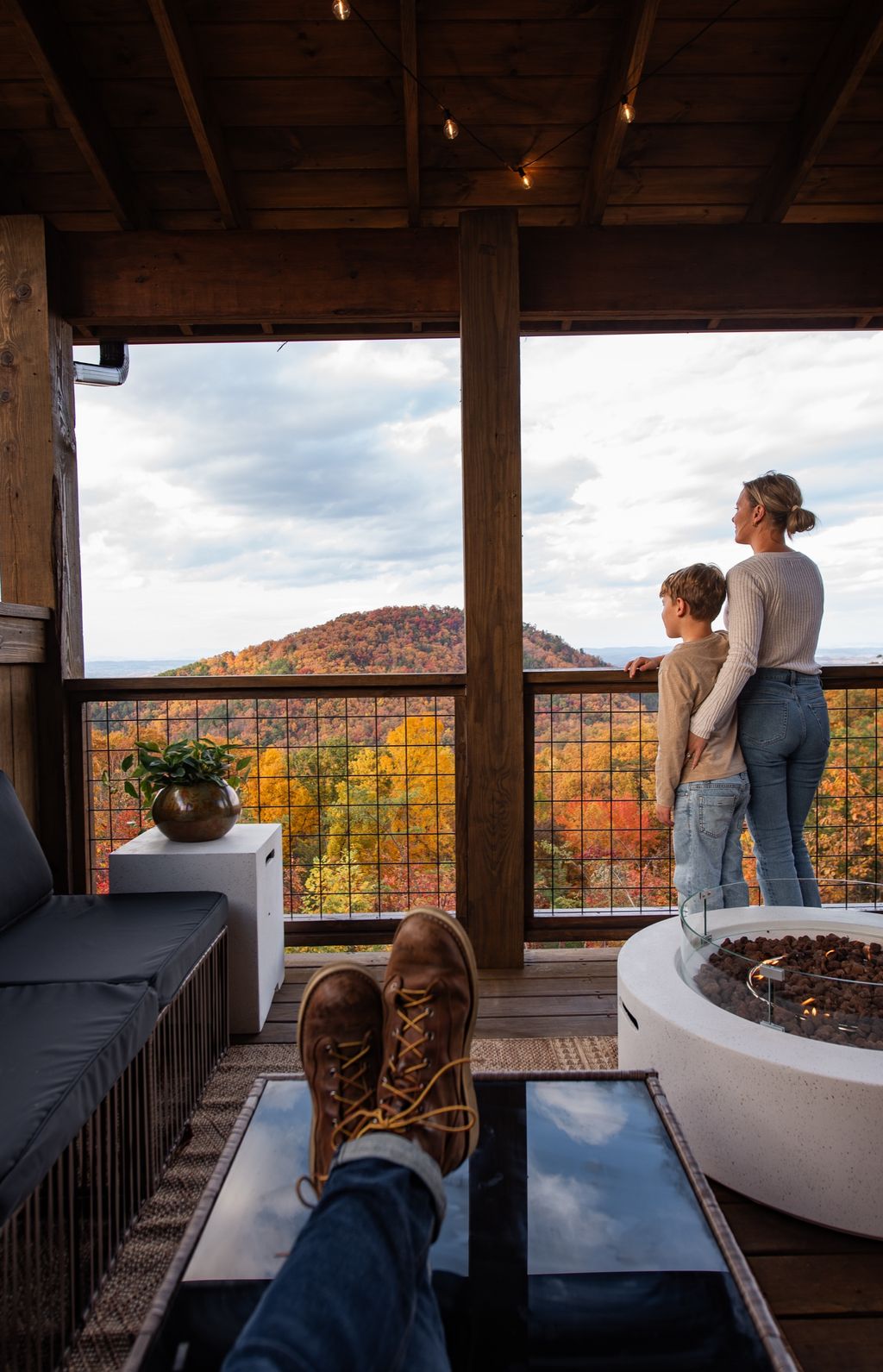 Family taking in the fall mountain view from the covered deck by the fire table