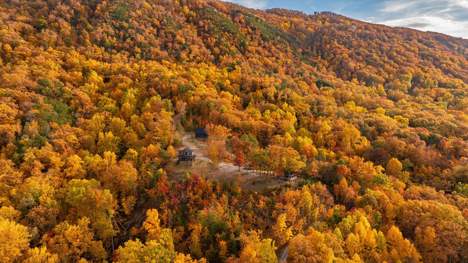 Aerial view of all three cabins on the private ridge in peak fall color